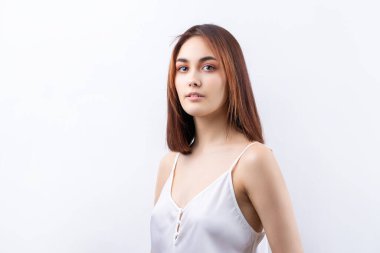 Temiz ciltli, doğal makyajlı ve gri arka planda beyaz dişli güzel bir kadın.