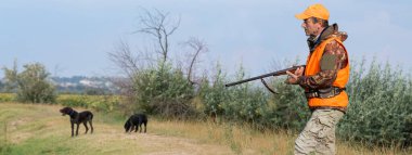Avlanırken av sırasında av hayvanı ya da av hayvanı arayan kamuflajlı bir avcı. Sonbahar av sezonu.