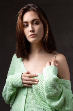 Stüdyoda uzun saçlı genç bir esmerin portresi. Koyu renkli dramatik fotoğraf.