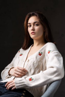 Stüdyoda uzun saçlı genç bir esmerin portresi. Koyu renkli dramatik fotoğraf.