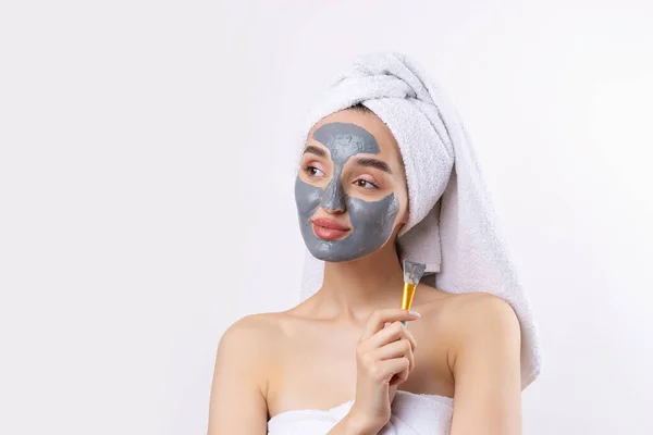 Een Vrouw Met Een Grijze Klei Cosmetische Masker Een Witte — Stockfoto