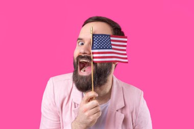 Kırmızı stüdyo arka planında Amerikan bayrağı olan sakallı, memnun bir gencin portresi. Büyük ABD vatansever ve özgürlüğün savunucusu.