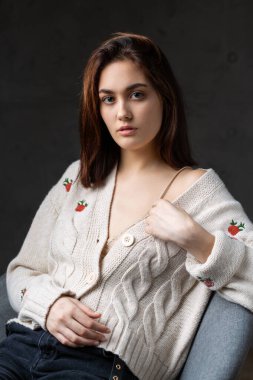 Stüdyoda uzun saçlı genç bir esmerin portresi. Koyu renkli dramatik fotoğraf.