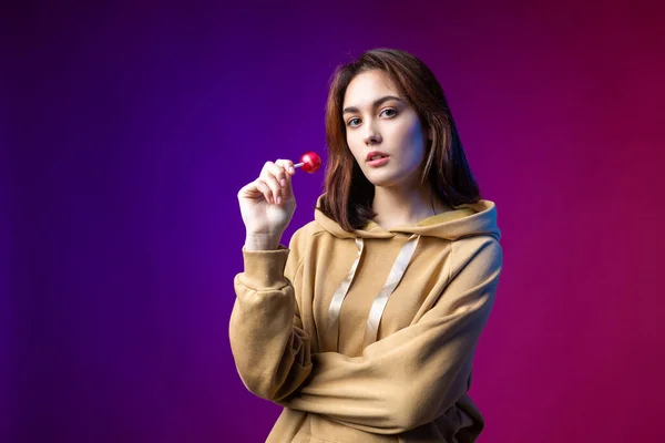 Retrato Uma Mulher Com Capuz Meninas Lambendo Pirulito Redondo Vermelho — Fotografia de Stock