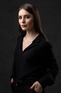 Stüdyoda uzun saçlı genç bir esmerin portresi. Koyu renkli dramatik fotoğraf.