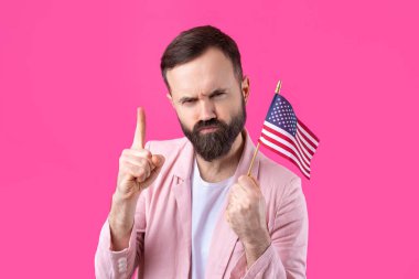 Kırmızı stüdyo arka planında Amerikan bayrağı olan sakallı, memnun bir gencin portresi. Büyük ABD vatansever ve özgürlüğün savunucusu.