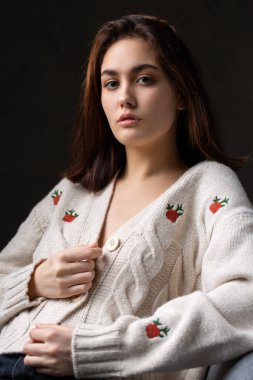 Stüdyoda uzun saçlı genç bir esmerin portresi. Koyu renkli dramatik fotoğraf.