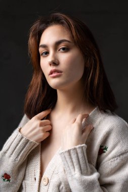 Stüdyoda uzun saçlı genç bir esmerin portresi. Koyu renkli dramatik fotoğraf.