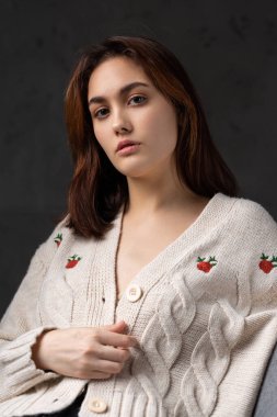 Stüdyoda uzun saçlı genç bir esmerin portresi. Koyu renkli dramatik fotoğraf.