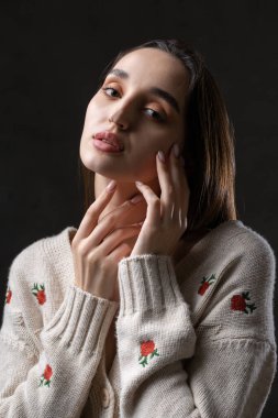 Stüdyoda uzun saçlı genç bir esmerin portresi. Koyu renkli dramatik fotoğraf.