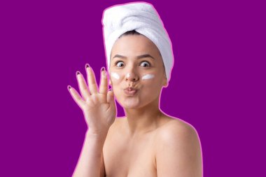 Kafasında beyaz havluyla menekşe arka planda güzel bir kadın portresi.