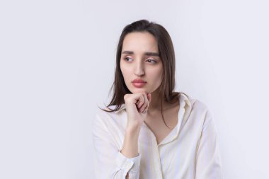 Beyaz arka planda soyutlanmış, düşünen güzel bir genç kadının portresi.