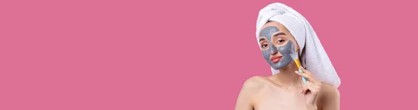 Een Vrouw Met Een Grijze Klei Cosmetische Masker Een Witte — Stockfoto