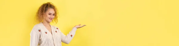 Uma Jovem Com Cabelo Encaracolado Aponta Com Gesto Fundo Estúdio — Fotografia de Stock