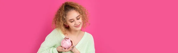巻き毛の可愛い少女が手にしたのは 貯金箱のピンクのピグレット お金の富と安全の概念 — ストック写真