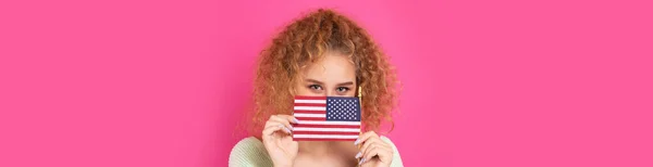 彼女の顔に笑顔の若い幸せな女の子は彼女の手にアメリカのフラグを保持しています 愛国心と自由の象徴 — ストック写真