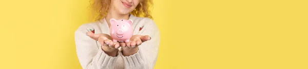 巻き毛の可愛い少女が手にしたのは 貯金箱のピンクのピグレット お金の富と安全の概念 — ストック写真