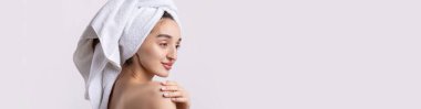 Kalın kaşlı güzel bir kız, beyaz arka planda mükemmel bir ten, kafasında havlu, güzel bir fotoğraf..