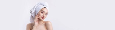 Kalın kaşlı güzel bir kız, beyaz arka planda mükemmel bir ten, kafasında havlu, güzel bir fotoğraf..
