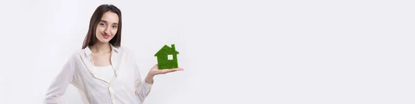 一个年轻的女地产经纪人手里拿着一座绿色房子的模型 出售生态不动产 — 图库照片