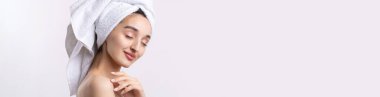 Kalın kaşlı güzel bir kız, beyaz arka planda mükemmel bir ten, kafasında havlu, güzel bir fotoğraf..