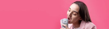 Pembe ceketli bir kadın bir paket dolar, açgözlülük, satış, yozlaşma konseptini yutar..