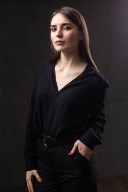 Stüdyoda uzun saçlı genç bir esmerin portresi. Koyu renkli dramatik fotoğraf.