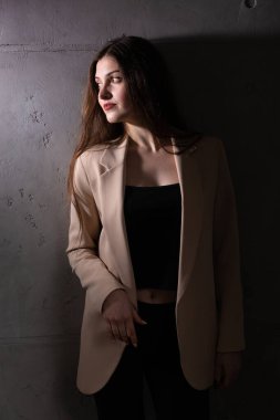 Stüdyoda uzun saçlı genç bir esmerin portresi. Koyu renkli dramatik fotoğraf.