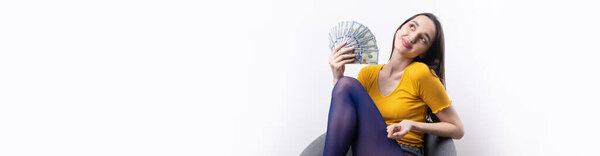Photo of rich woman in simple clothes holding fan of dollar money isolated on white background