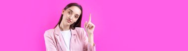 Kırmızı arka planda izole edilmiş pembe ceketli güzel bir genç kadının portresi.