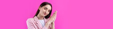Kırmızı arka planda izole edilmiş pembe ceketli güzel bir genç kadının portresi.