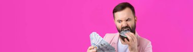 Pembe ceketli sakallı, mutlu genç bir iş adamının portresi kırmızı bir stüdyonun arka planında bize dolar banknotları gösteriyor. Tat, para kokusu..