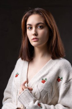 Stüdyoda uzun saçlı genç bir esmerin portresi. Koyu renkli dramatik fotoğraf.