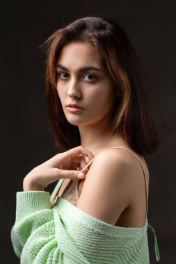 Stüdyoda uzun saçlı genç bir esmerin portresi. Koyu renkli dramatik fotoğraf.