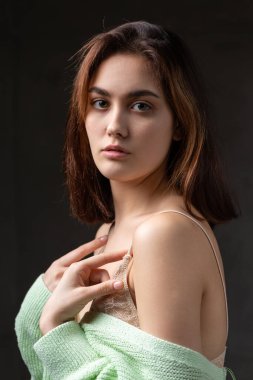 Stüdyoda uzun saçlı genç bir esmerin portresi. Koyu renkli dramatik fotoğraf.
