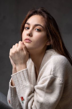 Stüdyoda uzun saçlı genç bir esmerin portresi. Koyu renkli dramatik fotoğraf.