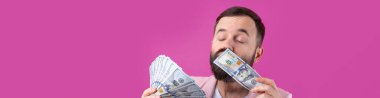 Pembe ceketli sakallı, mutlu genç bir iş adamının portresi kırmızı bir stüdyonun arka planında bize dolar banknotları gösteriyor. Tat, para kokusu..