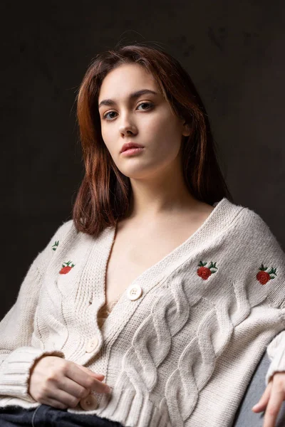 Stüdyoda uzun saçlı genç bir esmerin portresi. Koyu renkli dramatik fotoğraf.