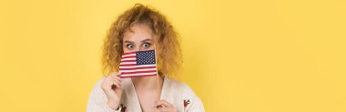 Yüzünde bir gülümseme olan genç mutlu bir kız ellerinde bir Amerikan bayrağı tutuyor. Vatanseverliğin ve özgürlüğün sembolü..