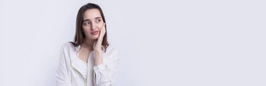 Beyaz arka planda soyutlanmış, düşünen güzel bir genç kadının portresi.
