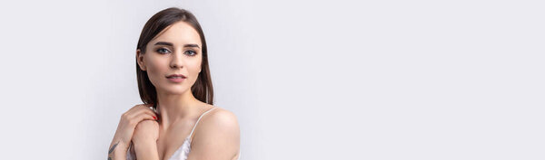 Красивая улыбающаяся женщина с чистой кожей, натуральным макияжем и белыми зубами на сером фоне