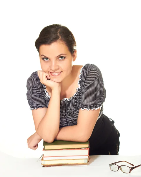 Привлекательная улыбающаяся девушка в блузке опирается на кучу книг — стоковое фото