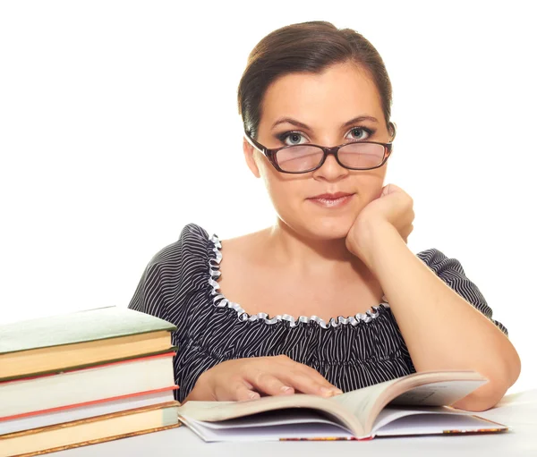 Attractive girl in a black blouse with glasses reading a book — Stock Photo, Image