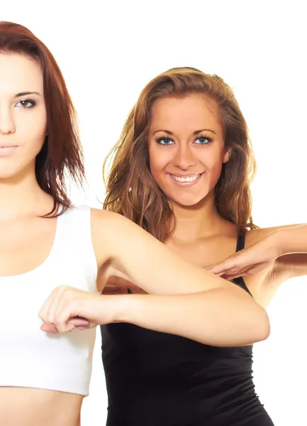 Two attractive girls in sports shirts do exercises. — Stock Photo, Image