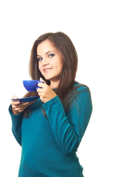 Muchacha sonriente atractiva en una camisa azul sosteniendo una taza azul y s — Foto de Stock