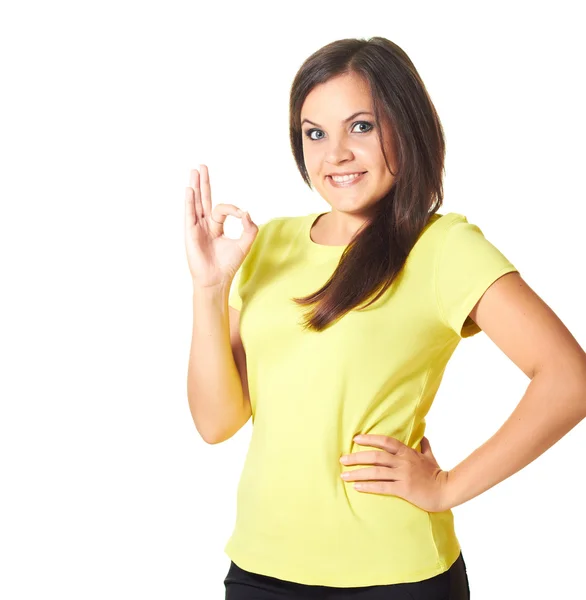 Atrakcyjny dziewczynka uśmiechający się w żółtą koszulkę pokazuje prawej porządku. — Zdjęcie stockowe