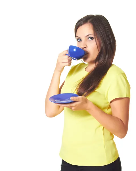 Attraktives Mädchen im gelben Hemd, das aus einer blauen Tasse trinkt und — Stockfoto