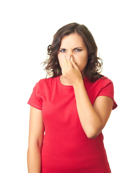 Attractive girl in a red shirt from the stench covers the nose. — Stock Photo, Image