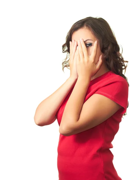 Menina atraente em uma camisa vermelha cobriu seu rosto com as mãos . — Fotografia de Stock