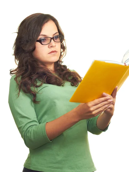 Aantrekkelijk meisje in een groen shirt en glazen lezen een gele bo — Stockfoto